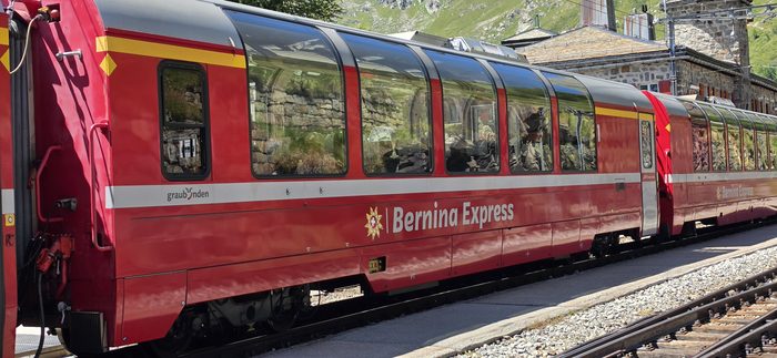 Czerwony skład Bernina Express na stacji na przełęczy