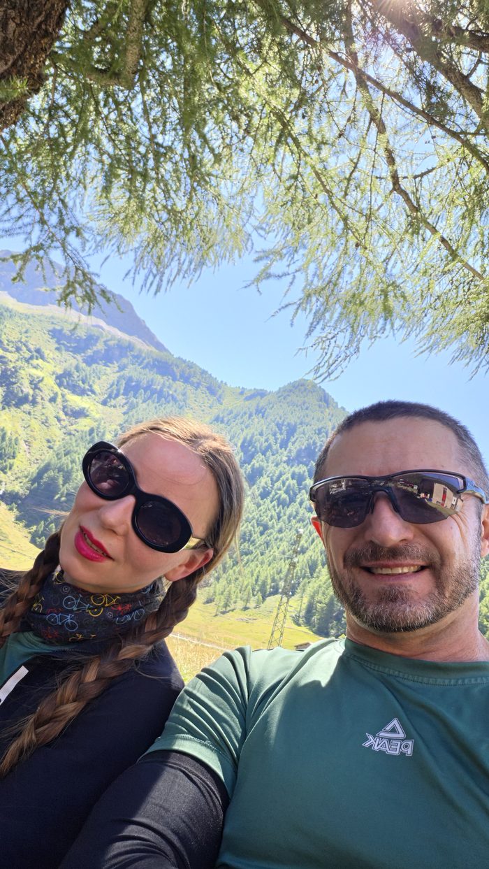 Portret pod modrzewiem, w tle alpejska dolina
