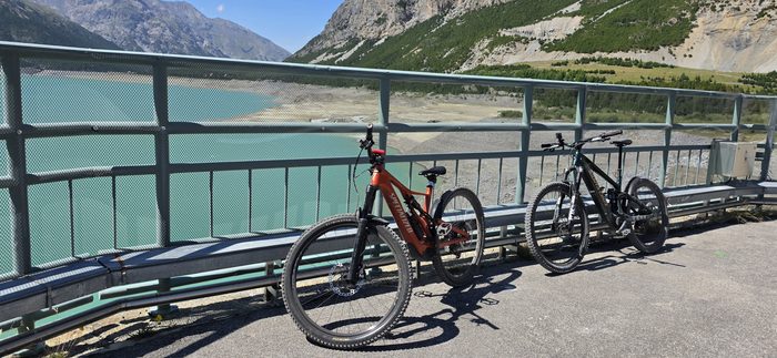 Dwa rowery oparte o barierkę nad zaporą Lago di Livigno